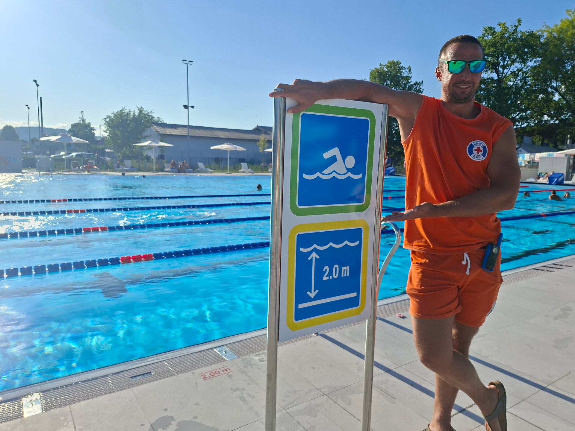 Reševalec iz vode ob olimpijskem bazenu z oznako globine 2 m